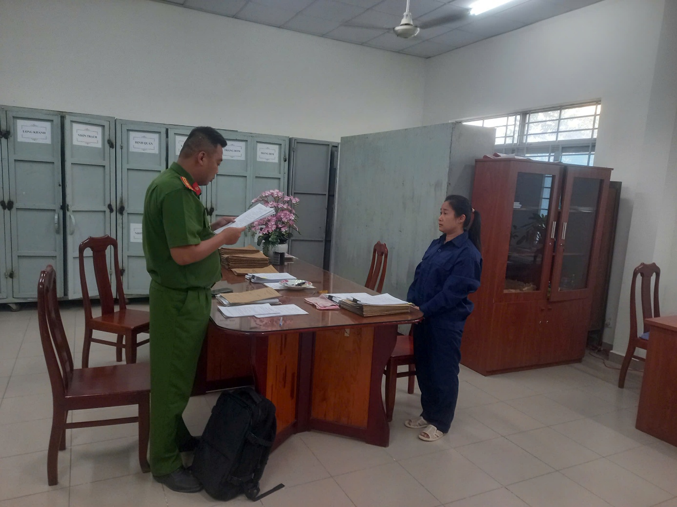 'Description: A person in uniform standing at a desk with a person in front of her

AI-generated content may be incorrect.'